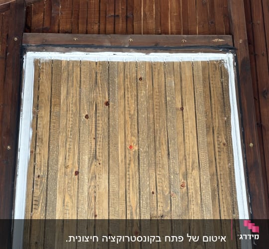 קיר עץ עם מסגרת כהה ולוחות עץ בהירים